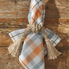 an orange and grey plaid tie with tassels hanging from it's end