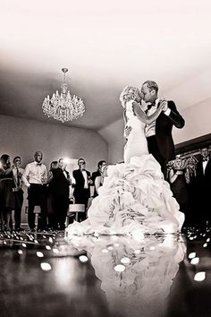 a bride and groom dance on the dance floor in front of their wedding party guests