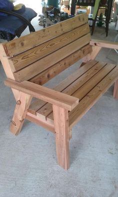 a wooden bench sitting on top of a cement floor