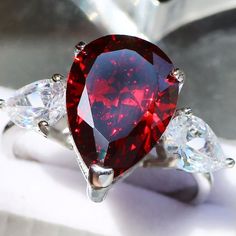 a red diamond ring sitting on top of a table