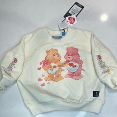 Super Cute Cream Care Bears Sweatshirt “Love Is In The Air” Cute Sweatshirt For Spring Playwear, Care Bears Stuff, Sweet Long Sleeve Tops With Graphic Print, Sweet Long Sleeve Graphic Print Top, Sweet Pink Tops With Cartoon Print, Cute Letter Print Sweatshirt For Playtime, Cute Sweatshirt With Letter Print For Playtime, Cute Cotton Sweatshirt For Playwear, Cute Cotton Playwear Sweatshirt