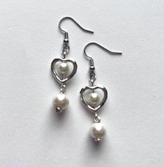 handmade earrings made by beadsadorbs! - made with glass beads, silver charms, acrylic beads and earring hooks made of nickel free metal! message me about customs! all custom requests are welcome! White Heart-shaped Pearl Charm Earrings, White Dangle Heart Earrings With Ear Wire, Silver Heart-shaped Pearl Earrings For Gift, White Heart Bead Dangle Earrings, White Dangle Heart Bead Earrings, White Heart Beads Dangle Earrings, White Dangle Heart Earrings With Beads, White Heart Charm Dangle Earrings, Silver Double Heart Bead Earrings