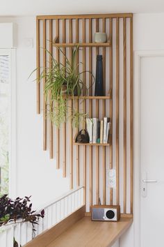 a wooden shelf with plants and books on it