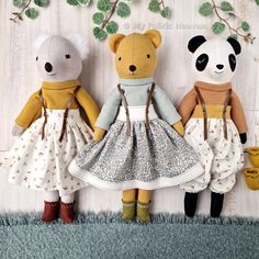 three teddy bears are dressed in dresses and boots