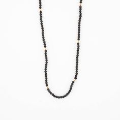 This beautiful Obsidian Beaded Necklace is edgy. elegant, and eye-catching, making it perfect for wearing by itself or layered with a simple chain necklace. The strand of pearls is punctuated with your choice of gold or silver beads for added interest. Note: We reinforce the necklace’s center silk cord with hidden knots—if your necklace breaks, most of the beads will remain intact and unaffected. For maximum life, we recommend you do not wear this necklace in water or during any rigorous activit Single Strand Necklaces With Round Beads For Layering, Minimalist Everyday Pearl Necklace With Beaded Chain, Everyday Minimalist Pearl Necklace With Beaded Chain, Minimalist Pearl Chain Necklace With Round Beads, Elegant Everyday Beaded Necklace, Minimalist Beaded Onyx Jewelry, Minimalist Everyday Necklace With Gemstone Beads, Everyday Onyx Jewelry With Black Beads, Minimalist Onyx Bead Jewelry