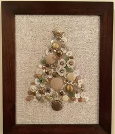 a christmas tree made out of buttons in a frame