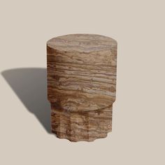 an object made out of wood sitting on top of a white surface with a shadow coming from it