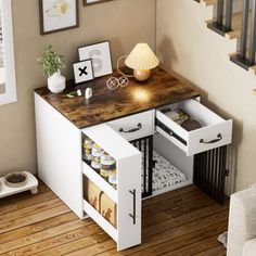 an open drawer in the corner of a room with pictures on the wall and stairs