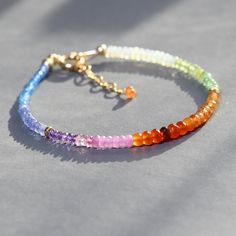 So fun and colorful this dainty beaded bracelet features melange of gems in rainbow hues. From one end to the other the gems used are: blue topaz, tanzanite, amethyst, pink sapphire, carnelian, garnet,  spessonite orange garnet, Ethiopian opal, citrine, peridot and arranged in sections. Made adjustable from7.25 to 8.5 inches.   Great on its own or layered with other gemstone bracelets. Awesome gift! gems  from 2 -3.5mm Thank you for looking! Please contact me if you have any questions or request Elegant Rainbow Bracelets With Round Beads, Elegant Rainbow Beaded Bracelets, Elegant Rainbow Round Beads Bracelet, Elegant Multicolor Beaded Crystal Bracelet, Adjustable Multicolor Faceted Beads Bracelets, Elegant Adjustable Rainbow Beaded Bracelets, Colorful Faceted Beaded Bracelets, Rainbow Faceted Beads Bracelet For Jewelry Making, Multicolor Faceted Beaded Bangle Bracelet