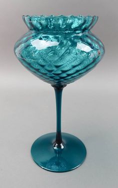 a blue glass vase sitting on top of a table