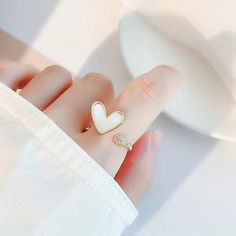 Stunning natural freshwater mother of pearl/shell statement cocktail ring, cute heart shaped signet, paved with zircon. Open and adjustable, easy to wear. Love & ocean theme, super unique and creative, elevate your dainty vibes. Perfect gift to treat yourself and your friends/family, you will get lots of compliments for sure! ♥ All of our jewelry are carefully handmade with delicate and exquisite details, all designed and made in Manhattan, New York. 💎 Features: ♥ Material: gold plated cooper ♥ Main stone: freshwater shell, mother of pearl ♥ Open adjustable size, fit US 4-9 ♥ Lightweight, easy to wear ♥ Nickel/Lead Free, Hypoallergenic 💎 Packing & Shipping: ♥ All our jewelry will be shipped with beautiful gift wrap packaging ♥ Handwrite gift notes/cards available upon request ♥ SAME DAY White Heart Ring For Gift, Trendy White Jewelry For Valentine's Day, Dainty White Adjustable Heart Ring, Trendy White Rings For Anniversary, Trendy White Heart-shaped Jewelry, Adjustable White Heart Ring, White Open Ring For Valentine's Day, Dainty White Heart Ring For Gift, Dainty White Heart Ring Gift