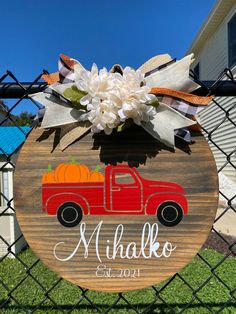 a wooden sign with a red truck and pumpkins on it