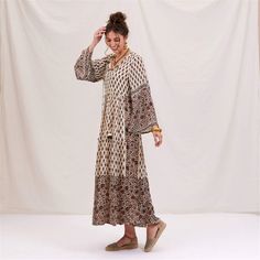 Step into boho bliss with the Julia Ecru & Black Bohemian Tiered Dress! Made from a dreamy blend of 50% modal and 50% viscose, this dress drapes beautifully for a flattering, comfortable fit. The playful full-length bell sleeves add a touch of elegance, while the open neck design keeps your look effortlessly chic. Fall in love with the unique details, like the long decorative tassels with cute accents and the contrasting design on the sleeves and bottom of the dress. With its ankle-length flow, Black Bohemian Dress, Black Bohemian, Decorative Tassels, Dress Drape, Open Neck, Eco Friendly Clothing, Dress Elegant, Bohemian Dress, Tiered Dress