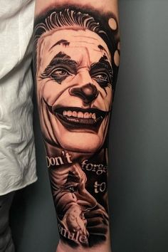 a man with a tattoo on his arm that has a joker face and the words don't forget to smile