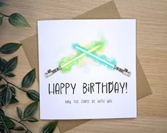 a birthday card with two lightsabes on it