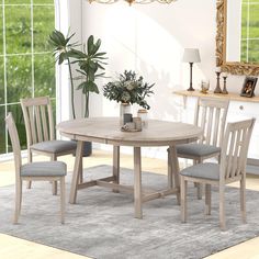 a dining table with four chairs and a potted plant