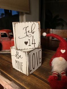 two wooden blocks that say love and one with an elf's head on top