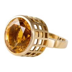 A citrine and 18 karat gold ring, by Sweden's most important and most versatile modernist designer, Sigurd Persson, c. 1955. This ring is a size 5 and stamped with maker marks SIGP, Swedish hallmarks, and 18k. It is highly collectible and comes with its original box. Persson had a way of showcasing the luminosity of the stones he used. If you look at a variety of his rings, you will see his design inclination towards gold grids with cutouts rising high above the shank, in which he exposes the st Modern Yellow Gold Topaz Ring With Polished Finish, Modern Gold Topaz Ring, Modern Citrine Rings For Formal Occasions, Modern Yellow Gold Citrine Ring, Modern Citrine Ring In Yellow Gold, Modern Formal Hallmarked Topaz Ring, Modern Citrine Yellow Gold Ring, Modern Gold Topaz Ring, Hallmarked, Vogue Jewelry