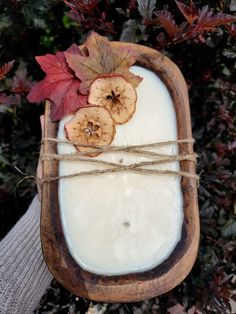 a wooden tray with apples and leaves on it