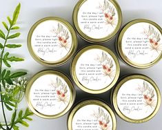 four gold tins with flowers and verse on them sitting next to a potted plant