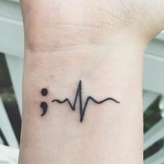 a small tattoo on the wrist of a person with a heart beat sign in it