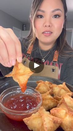 a woman is holding up some food to her face and she is about to eat it