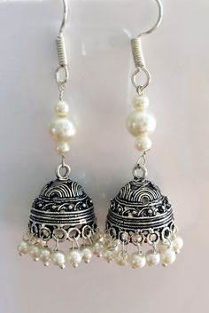 PEARL JHUMKA EARRINGS Jhumkas are the calling on the runway ramps this year. This is a traditional artist Jhumki handmade with love. Finished up with beautiful white pearls , A very hot pair for this season. The length of the earrings is 2.5 inches from top to the tip of the earring. lightweight ' If you want unique this season then these are a pair you must own. wear temple art and become a part of rich tradition. Thank you for your support Go back to Storefront Taneesijewelry.etsy.com View my Silver Earrings With Bells For Festivals, Silver Bell Earrings For Festivals, White Bohemian Earrings For Diwali, Bohemian White Earrings For Diwali, White Latkans Earrings For Navratri, Silver Jhumkas For Navratri, Elegant Silver Jhumkas For Festival, White Danglers With Latkans For Navratri, Silver Bollywood Jhumkas With Matching Earrings