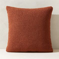 an orange pillow sitting on top of a white table