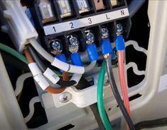 multiple wires are connected to the inside of an electrical panel with different colors and sizes