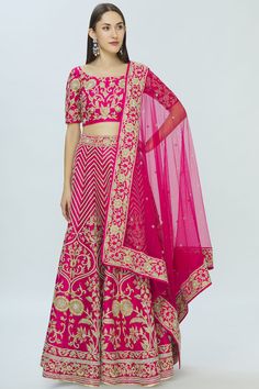 Fuschia floral embroidered lehenga paired with blouse and dupatta. 
Components:3
Embroidered
Neckline:Round
Sleeve Length:Elbow
Fabric:Dupion Raw Silk
Color:Pink
Back tassle tie-up blouse 
Embroidered floral lace border on dupatta
Closure:  
Lehenga: Side tassle detail  drawstring tie-up and side zip 
Blouse: Side zip - Aza Fashions Bollywood Embroidered Sets For Reception, Bollywood Style Embroidered Reception Sets, Floor-length Embroidered Sets For Reception, Embroidered Floor-length Dola Silk Set, Embroidered Sets For Diwali Reception, Floor-length Embroidered Kundan Sets, Chanderi Embroidered Sets For Reception, Traditional Drape Sharara With Resham Embroidery For Reception, Embroidered Kundan Floor-length Sets