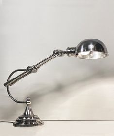 an old fashioned desk lamp on a white table