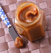 a jar filled with peanut butter next to a knife