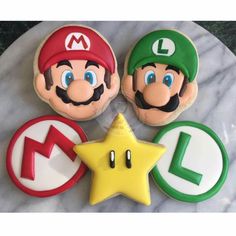 four decorated cookies with mario and luigi on them