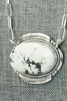 This white buffalo and sterling silver necklace was made by Zuni silversmith Kenny Calavaza. The back of the necklace is signed K. C. and Zuni, NM.Necklace: 17"Length: 1 3/8"Width: 1 7/8"Free shipping on all orders! We ship with USPS and always include tracking. All orders ship within a day of payment.Returns are accepted up to 30 days after you receive your order. Just send us a message. Our shop offers cash back or store credit. The item must be returned in new condition. Southwestern Style Necklace With Large Oval Stone, Southwestern Style Oval Necklace With Large Stone, Southwestern Oval Necklace With Large Stone, Southwestern Silver Necklace With Oval Pendant, White Pendant Necklace With Sterling Silver Clasp, White Pendant Jewelry With Sterling Silver Clasp, White Southwestern Sterling Silver Jewelry, Southwestern White Oval Jewelry, Southwestern Style Oval White Jewelry