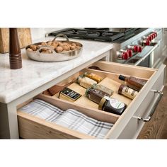 an open drawer in a kitchen filled with food