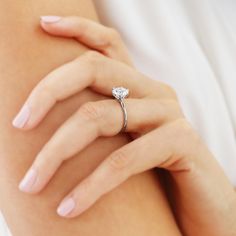 a woman's hand with a diamond ring on it