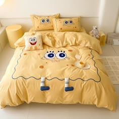 a yellow bed with two pillows and some stuffed animals on the pillowcase in front of it