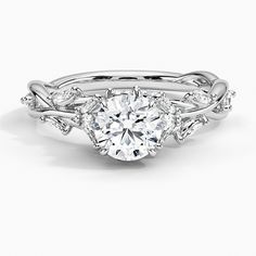 a white gold engagement ring with an oval cut diamond surrounded by leaf and vine accents