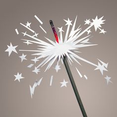 a close up of a sparkler with stars in the sky behind it on a gray background