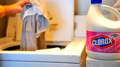 a bottle of clorox liquid sitting on top of a washer and dryer