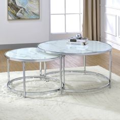 two glass tables sitting on top of a white rug