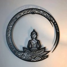 a metal wall hanging with a buddha sitting on a boat in the middle of it