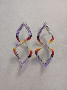 Beautiful hand made beaded earrings.  Spiral Earrings Colors: Purple w/fire colors Size: 3 1/2 inches Spiral Beaded Earrings, American Quilts Patterns, Handmade Beaded Earrings, Seed Bead Crafts, Quilts Patterns, Handmade Earrings Beaded, Colors Purple, Spiral Earrings, Crown Jewels