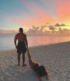 a man standing on top of a beach next to a woman laying on the ground