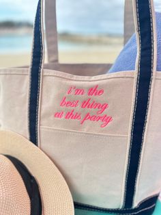 a tote bag sitting on top of a table next to a hat and beach towel