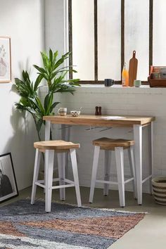 two stools sit in front of a table with a potted plant on it