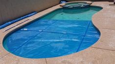 an empty swimming pool in the middle of a patio with blue tarps around it