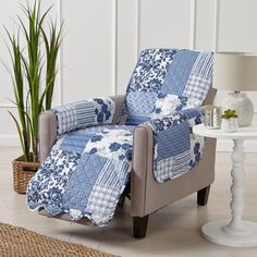 a blue and white patchwork chair next to a potted plant