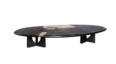 an oval table with black and white designs on the top, sitting in front of a white background