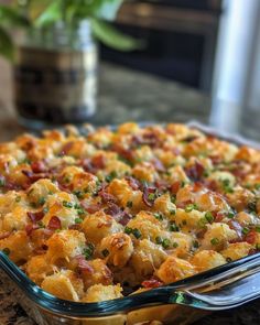 a casserole dish with bacon, cheese and green onions in it on a table